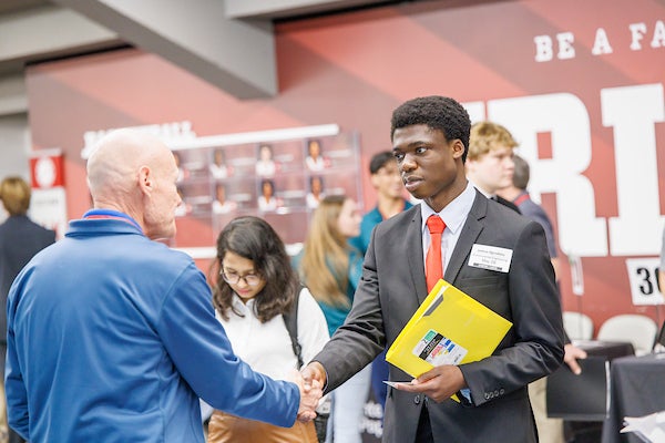Student shaking hands with person at career fair