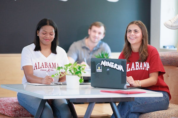 two people at a table with a laptop